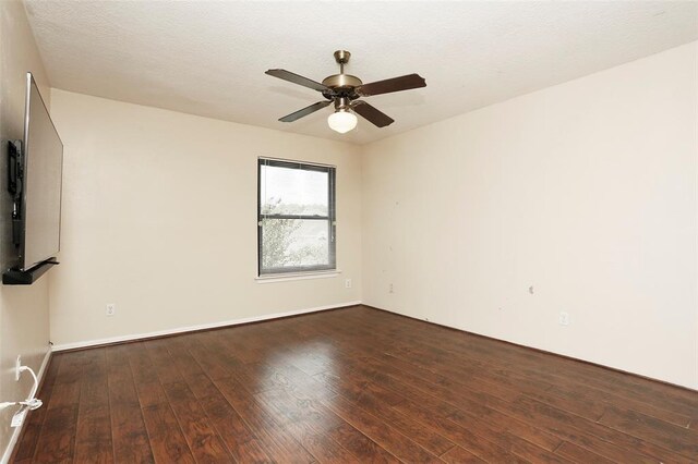 empty room with a textured ceiling, ceiling fan, and dark hardwood / wood-style floors