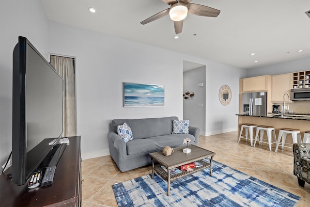 tiled living room with ceiling fan and sink