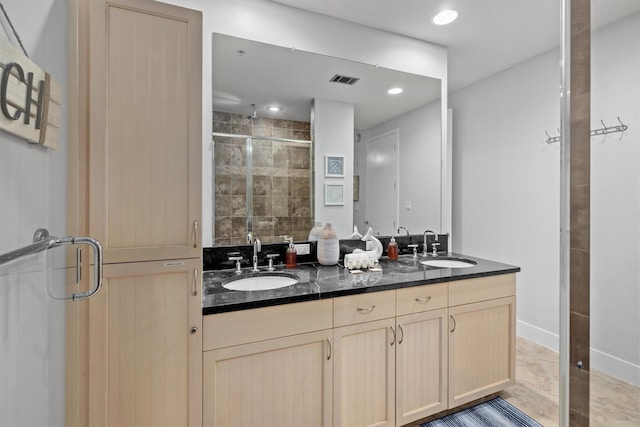 bathroom featuring tile patterned flooring, vanity, and a shower with shower door