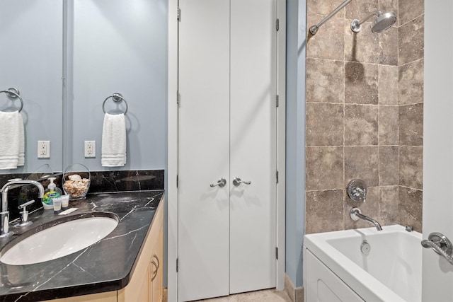 bathroom featuring vanity and tiled shower / bath