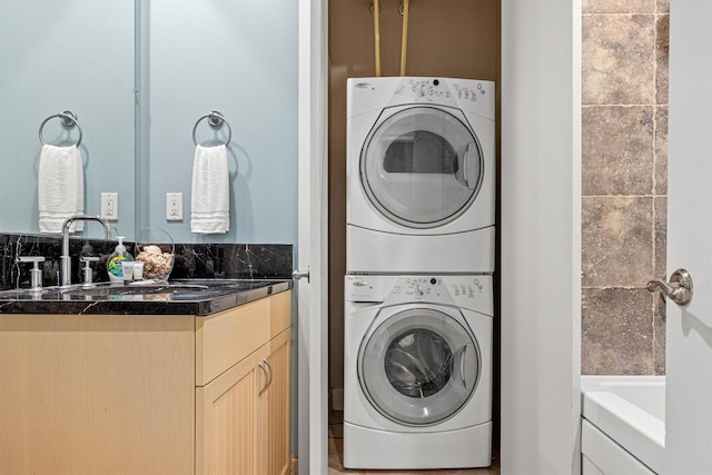 laundry room with stacked washer / drying machine and sink