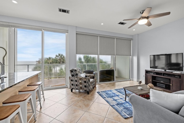 living room featuring light tile patterned floors and ceiling fan