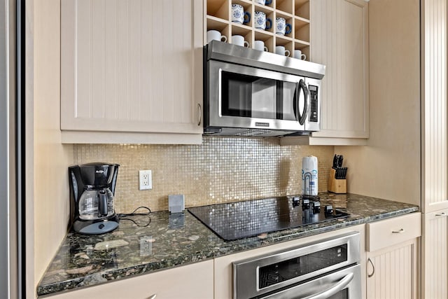 kitchen featuring dark stone countertops, decorative backsplash, and appliances with stainless steel finishes