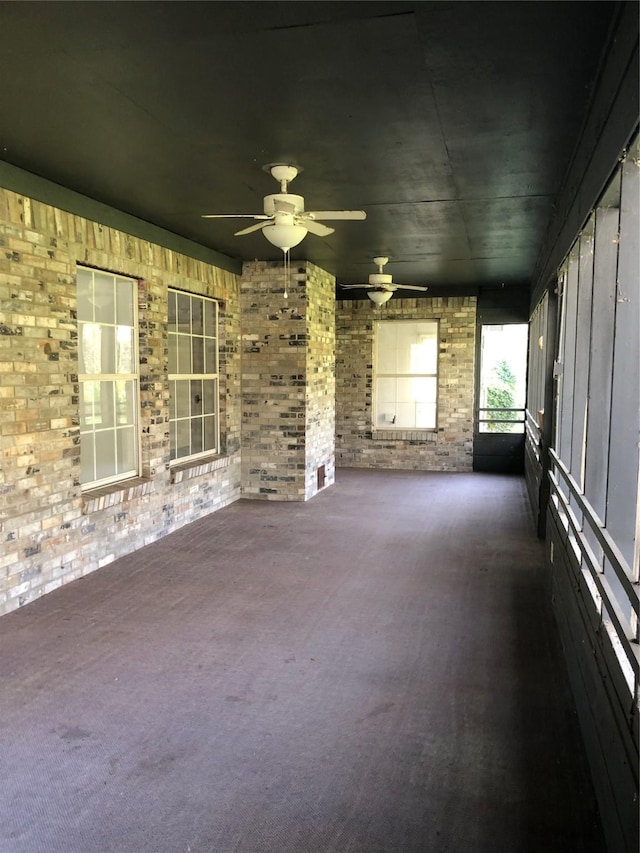 unfurnished sunroom with ceiling fan