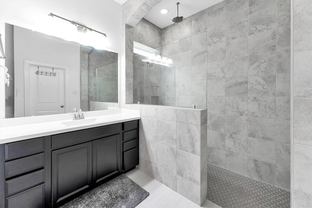 bathroom featuring a tile shower, tile patterned floors, and vanity