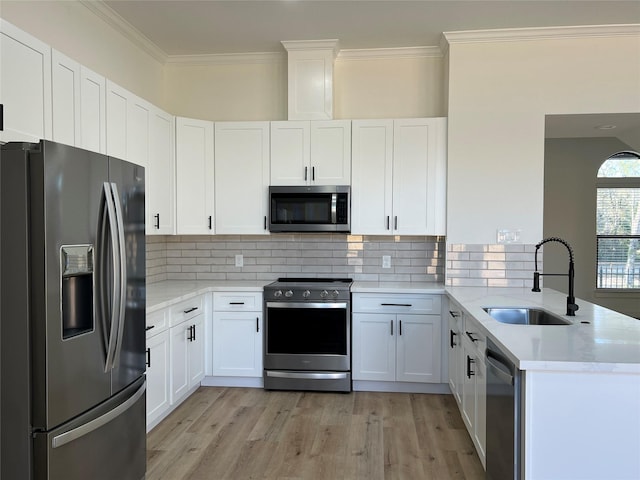 24555 Kerry St, Hempstead, TX 77445 - kitchen with appliances with stainless steel finishes, light wood-style floors, a peninsula, ornamental molding, and tasteful backsplash