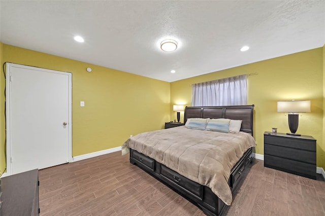 bedroom with a textured ceiling and hardwood / wood-style flooring