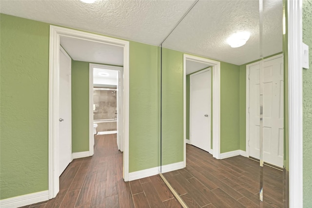 unfurnished bedroom with a textured ceiling, a closet, and dark hardwood / wood-style floors