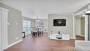 living room with a chandelier and dark wood-type flooring