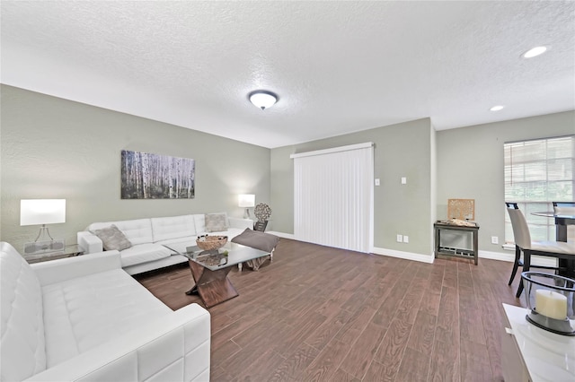 living room featuring a textured ceiling and dark hardwood / wood-style floors