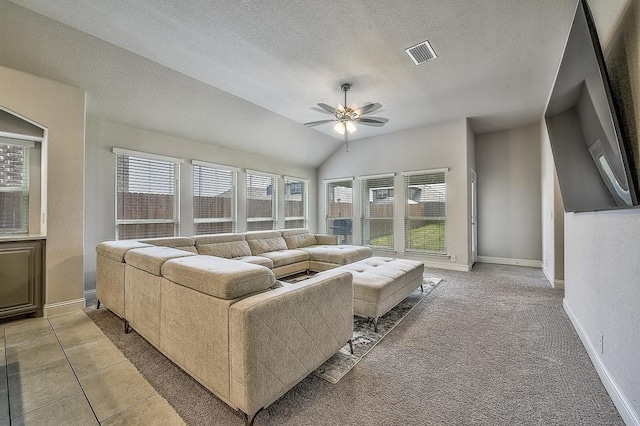 living room featuring tile patterned flooring, a textured ceiling, vaulted ceiling, and ceiling fan