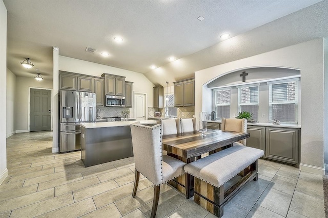 dining area featuring a textured ceiling, a wealth of natural light, lofted ceiling, and sink