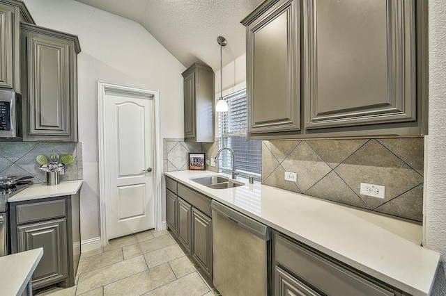 kitchen with backsplash, sink, hanging light fixtures, vaulted ceiling, and stainless steel appliances