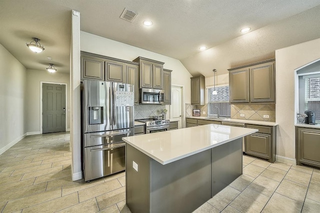 kitchen featuring plenty of natural light, stainless steel appliances, vaulted ceiling, and sink