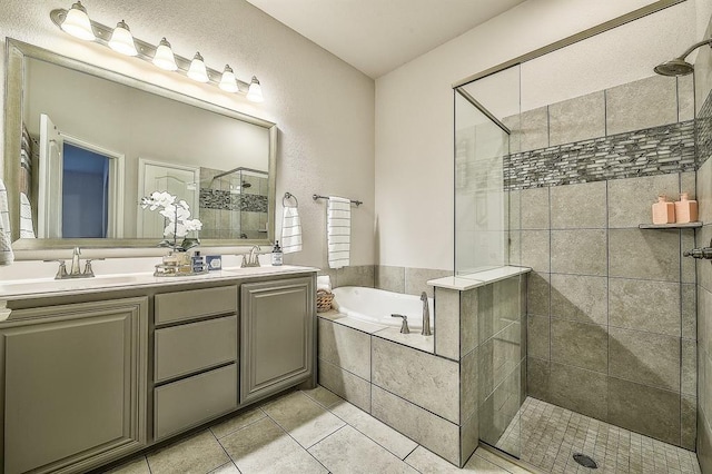 bathroom featuring tile patterned flooring, vanity, and plus walk in shower