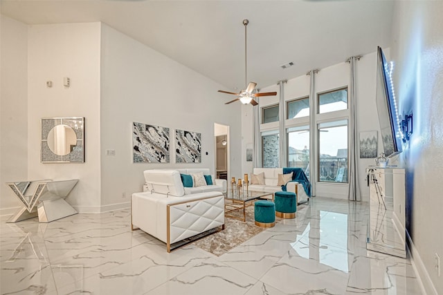 living room featuring ceiling fan and a high ceiling