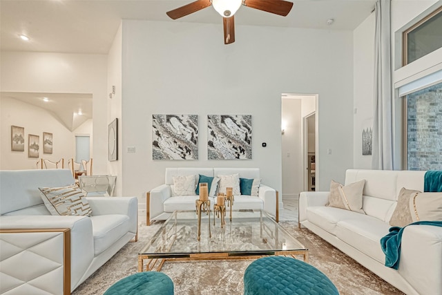 living room featuring ceiling fan and a high ceiling