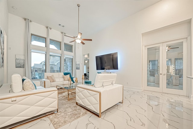 living room with ceiling fan, a high ceiling, and french doors