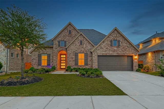 view of front of home with a yard and a garage