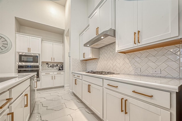 kitchen featuring appliances with stainless steel finishes, ventilation hood, white cabinetry, and tasteful backsplash