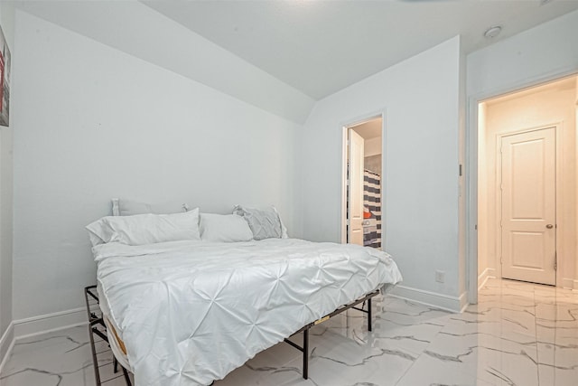 bedroom with a walk in closet and vaulted ceiling