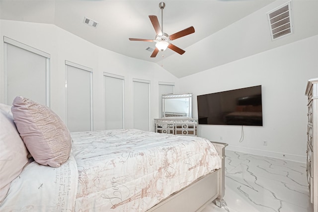 bedroom featuring ceiling fan, lofted ceiling, and two closets