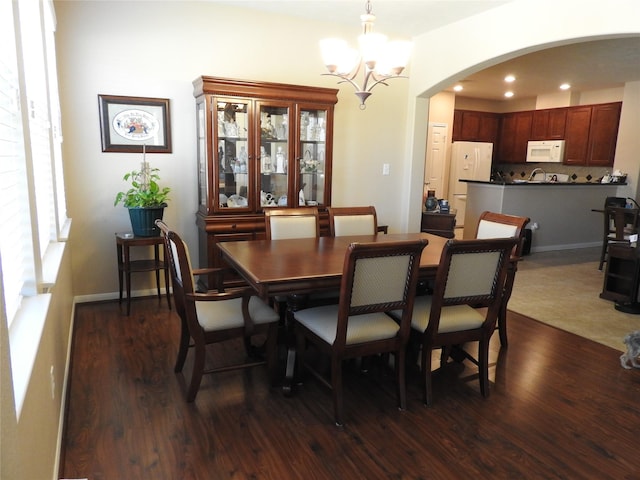 dining room featuring dark wood-type flooring and an inviting chandelier