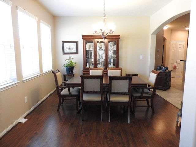 dining area with an inviting chandelier and dark wood-type flooring