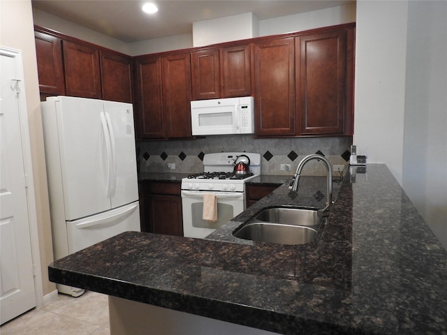 kitchen with white appliances, sink, decorative backsplash, dark stone countertops, and light tile patterned floors