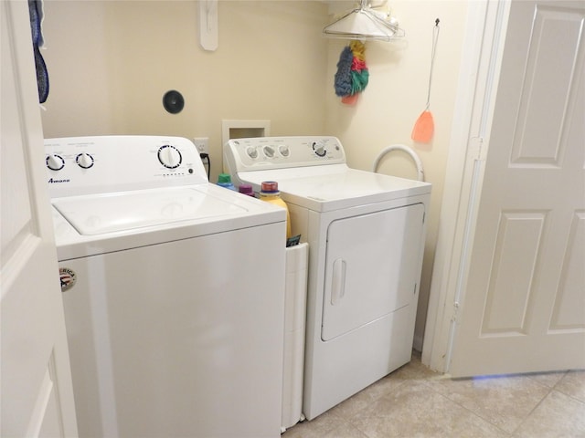 laundry room with light tile patterned floors and washer and clothes dryer