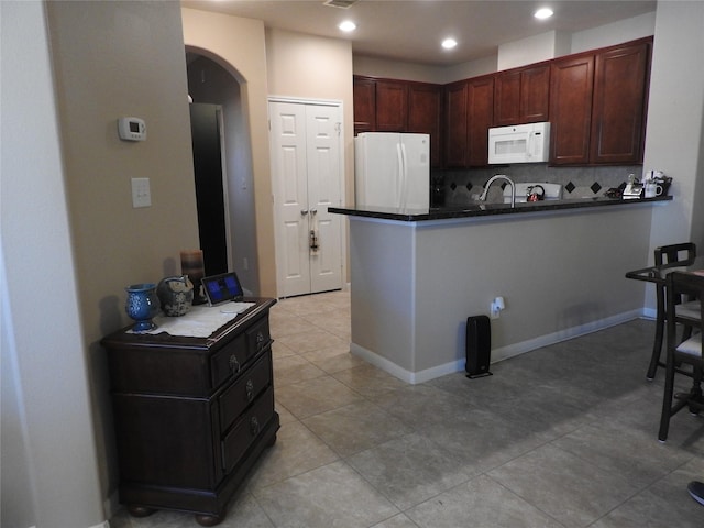 kitchen with kitchen peninsula, tasteful backsplash, white appliances, sink, and light tile patterned flooring