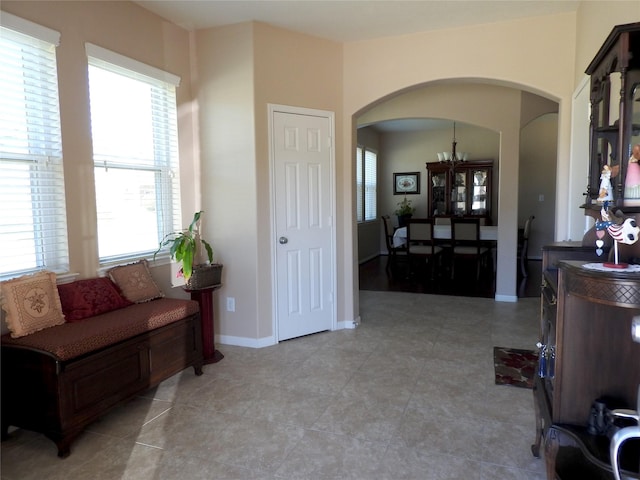 sitting room featuring a chandelier and light tile patterned flooring