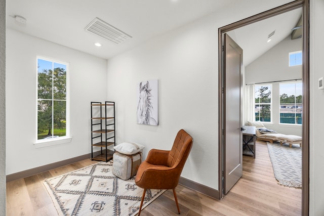 living area with light hardwood / wood-style flooring and vaulted ceiling