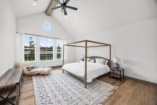 bedroom with hardwood / wood-style floors, high vaulted ceiling, ceiling fan, and beam ceiling