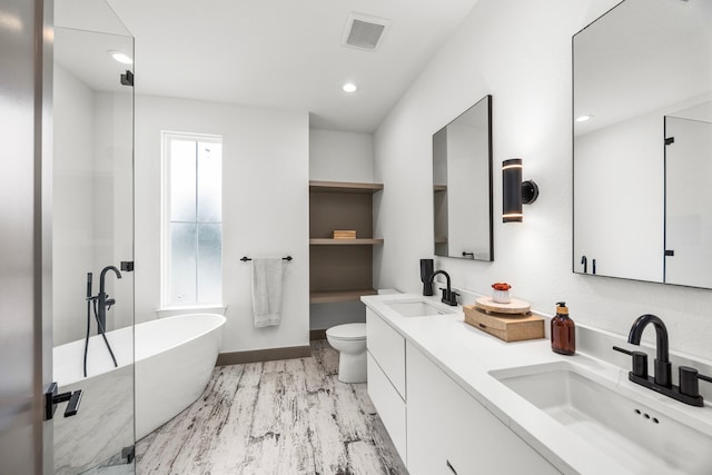 bathroom featuring hardwood / wood-style floors, vanity, toilet, and a tub