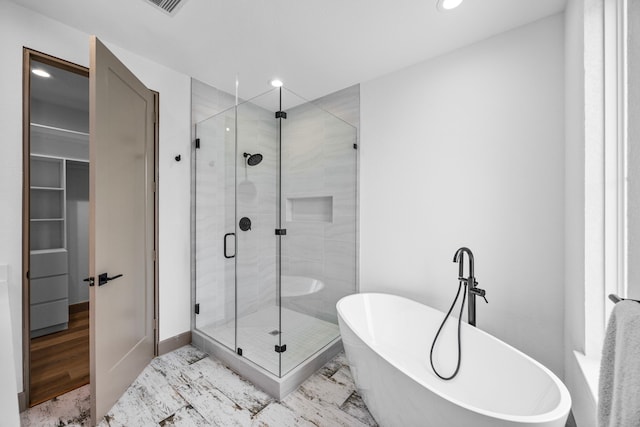 bathroom with plus walk in shower and hardwood / wood-style floors