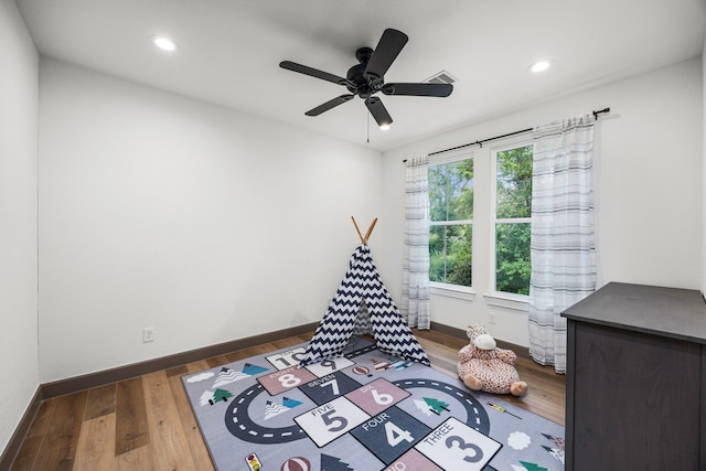 recreation room featuring dark hardwood / wood-style floors and ceiling fan