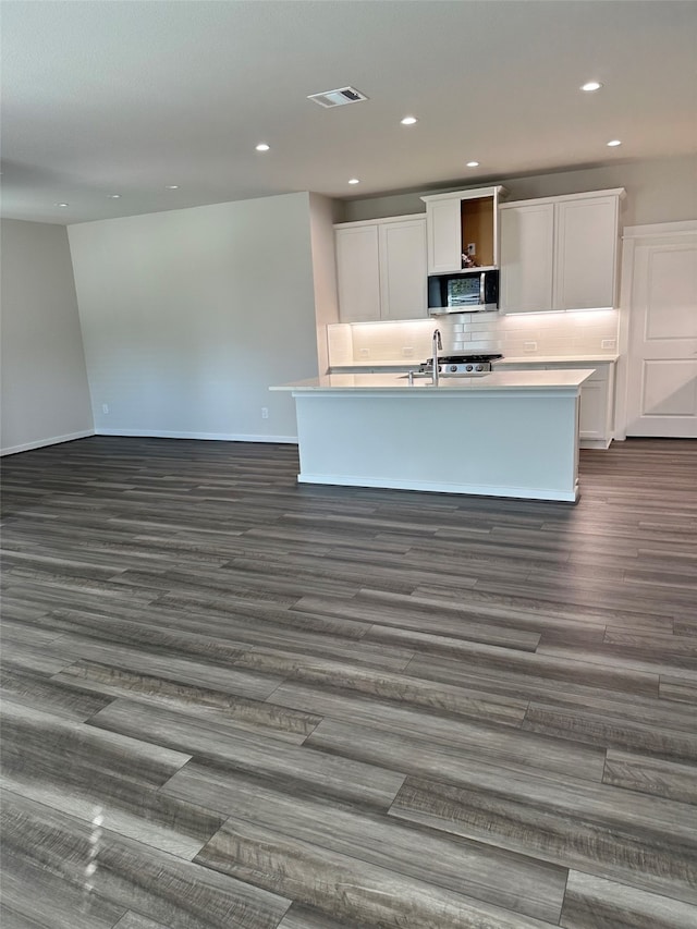 kitchen with white cabinetry, an island with sink, and dark hardwood / wood-style floors