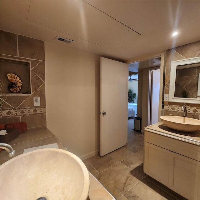 bathroom with vanity and tile walls