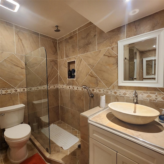 bathroom with toilet, a tile shower, tile walls, and tasteful backsplash