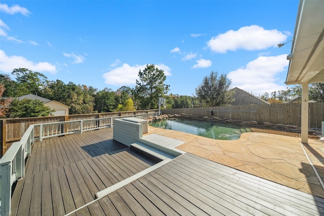 wooden terrace featuring a patio area and a fenced in pool