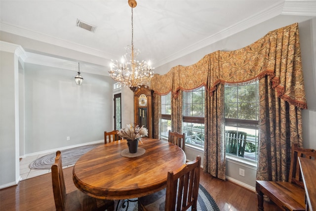 dining room with dark hardwood / wood-style floors, an inviting chandelier, and crown molding