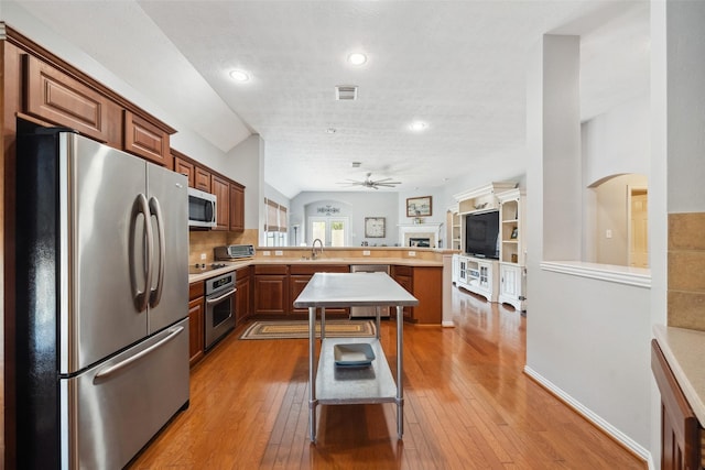 kitchen with ceiling fan, sink, stainless steel appliances, and hardwood / wood-style flooring