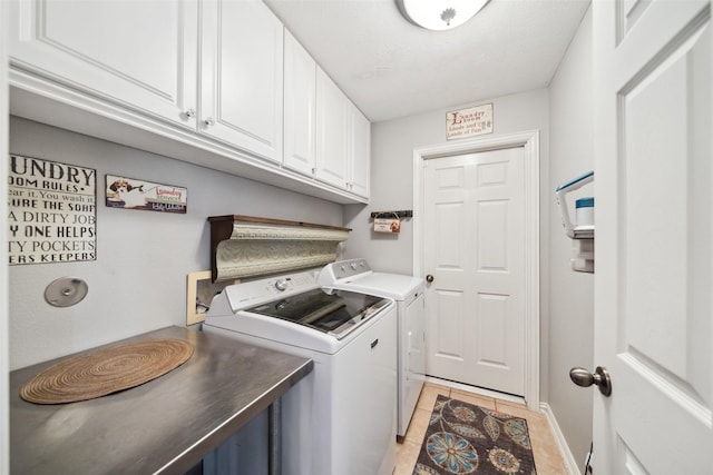 washroom with cabinets, separate washer and dryer, a textured ceiling, and light tile patterned floors