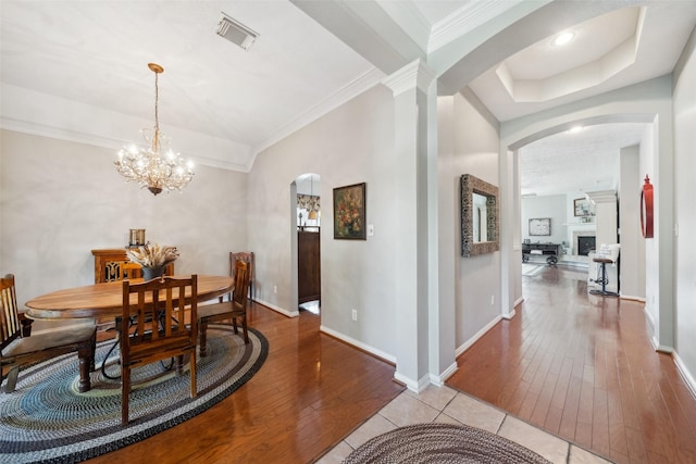 dining area featuring crown molding, a notable chandelier, and light wood-type flooring