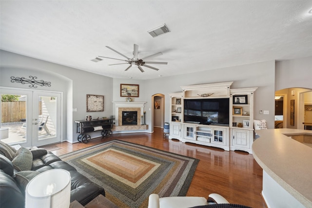 living room featuring a fireplace, ceiling fan, french doors, and wood-type flooring