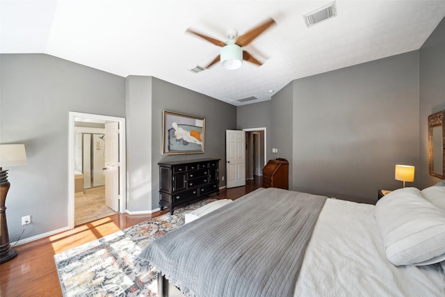 bedroom featuring ceiling fan, light wood-type flooring, connected bathroom, and lofted ceiling