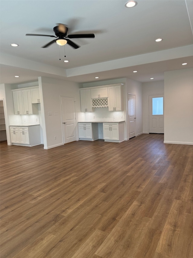 unfurnished living room featuring ceiling fan and dark hardwood / wood-style flooring