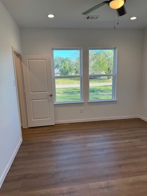 spare room featuring ceiling fan and dark wood-type flooring