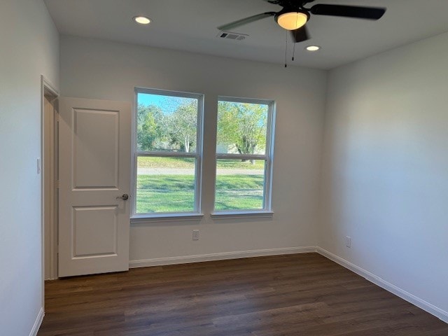 spare room with dark hardwood / wood-style flooring and ceiling fan